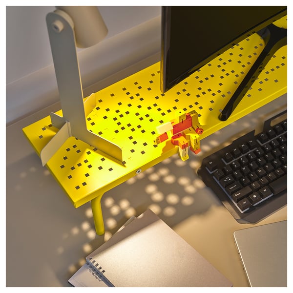 Support de moniteur de jeu jaune vif avec clavier, ordinateur portable et ordinateur portable noirs sur un bureau, améliorant l’ergonomie de l’espace de travail.