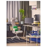 Bureau à domicile moderne avec support LÅNESPELARE, chaise gris-vert, bureau, plantes, livres, canapé bleu.