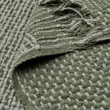Plaid tissé à la main dans des tons gris-vert foncé, avec un mélange de coton et de laine pour plus de chaleur et de confort. Texture complexe visible.