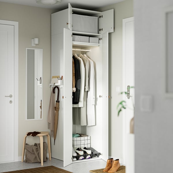 Une armoire ouverte avec manteaux, chaussures et rangement suspendu.