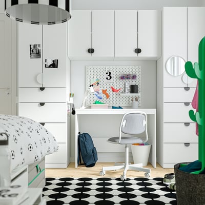 Chambre d’enfant moderne avec meubles blancs, chaise grise, sac à dos, poignées en LATMASK .