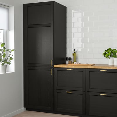 Armoire de cuisine LERHYTTAN noire avec poignées dorées, placage de frêne et cadre en bois massif.