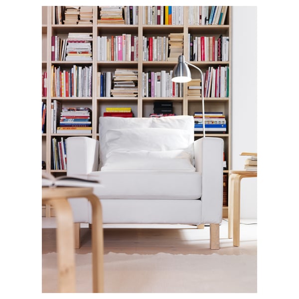Coin confortable avec lampe LERSTA, fauteuil et étagère.
