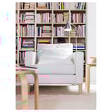Coin confortable avec lampe LERSTA, fauteuil et étagère.
