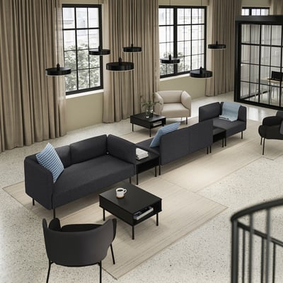 Salon moderne avec canapé modulaire LILLEHEM en gris, tables basses noires, suspensions noires et grandes fenêtres avec rideaux beiges.