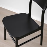 Chaise moderne noire avec cadre en métal élégant et assise incurvée ; design minimaliste.