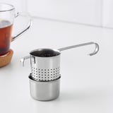 L’infuseur à thé en acier inoxydable est suspendu sur le bord de la tasse, avec support pour une préparation de thé sans gâchis.