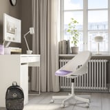 Bureau à domicile minimaliste : chaise LOBERGET, bureau avec ordinateur et lampe, fenêtre avec plante.