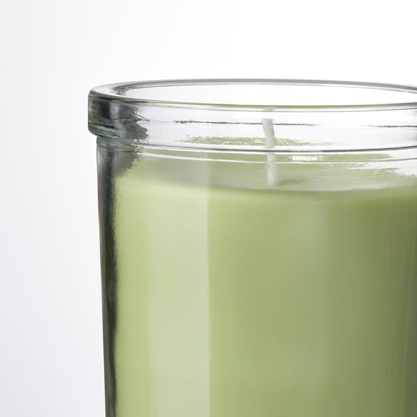 Bougie vert vif en verre transparent, éclairant la pièce avec un parfum de pomme croquant.