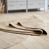 Tapis LOHALS, jute naturel, tissé à plat, sur parquet.