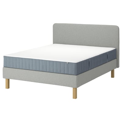 Lit LYNGÖR gris avec matelas blanc, pieds en bois, tête de lit rembourrée.