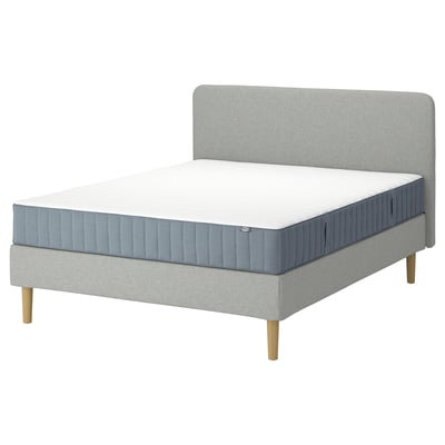 Un lit LYNGÖR gris clair avec un matelas assorti, doté d’une tête de lit rembourrée, de pieds en bois et de cinq zones de confort.