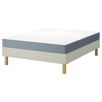 Cadre de lit IKEA LYNGÖR et ensemble matelas blanc et bleu, avec des pieds en bois et un matelas blanc aux côtés et coins bleus.