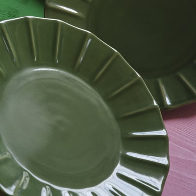 Assiette en grès émaillé vert, bord festonné, design artisanal.
