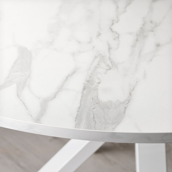 Gros plan d’une table ronde blanche aux bords épurés, mettant en valeur son design moderne lisse et élégant.