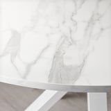 Gros plan d’une table ronde blanche aux bords épurés, mettant en valeur son design moderne lisse et élégant.
