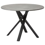 Table de salle à manger ronde moderne avec plateau en béton gris et pieds entrecroisés en métal noir.