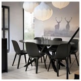 Ensemble de cuisine/salle à manger moderne avec une table en marbre noir, quatre chaises assorties, des suspensions et une peinture murale représentant deux cerfs dans une forêt brumeuse.