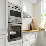 Cuisine moderne avec four et micro-ondes intégrés, dotée d’un affichage numérique, d’une cuisson par convection et d’un élégant fini argenté.