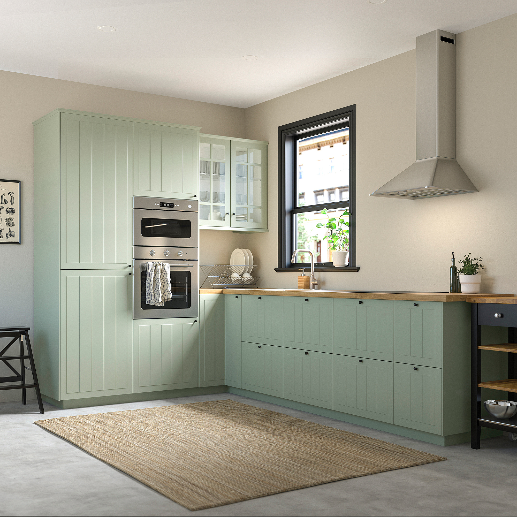 Cuisine moderne, armoires vertes, électroménagers en acier, comptoirs en bois, grande fenêtre, tapis beige.