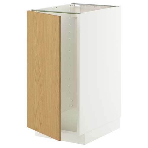 Un meuble de cuisine METOD blanc avec une porte en chêne clair et un cadre robuste. Il a un design moderne avec un look épuré et simple.
