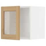 Un meuble de cuisine en bois blanc et chêne avec une porte en verre transparent. L’armoire est rectangulaire et la porte a des bords biseautés.