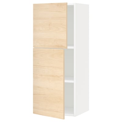 Armoire en bois clair et blanc, deux portes s’ouvrent laissant apparaître des étagères.