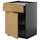 Une armoire de cuisine METOD ouverte avec une finition en bois clair et un intérieur noir. Il dispose d’un tiroir et de deux étagères.