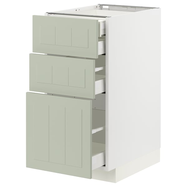 Unité de cuisine moderne avec trois tiroirs verts et armoire blanche.