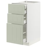 Unité de cuisine moderne avec trois tiroirs verts et armoire blanche.