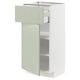 Une armoire de cuisine METOD blanche avec des portes et des étagères en stensund vert. Il a un design moderne et minimaliste avec un tiroir ouvert et une porte à charnières.