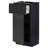 Armoire de cuisine noire moderne avec un tiroir et une porte ouverts, une finition mate élégante, un cadre en panneaux de particules robuste.
