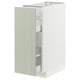 Un meuble de cuisine METOD avec une porte en stensund vert. Il a des tiroirs coulissants et une finition blanche. L’armoire est rectangulaire et a un design moderne et élégant.