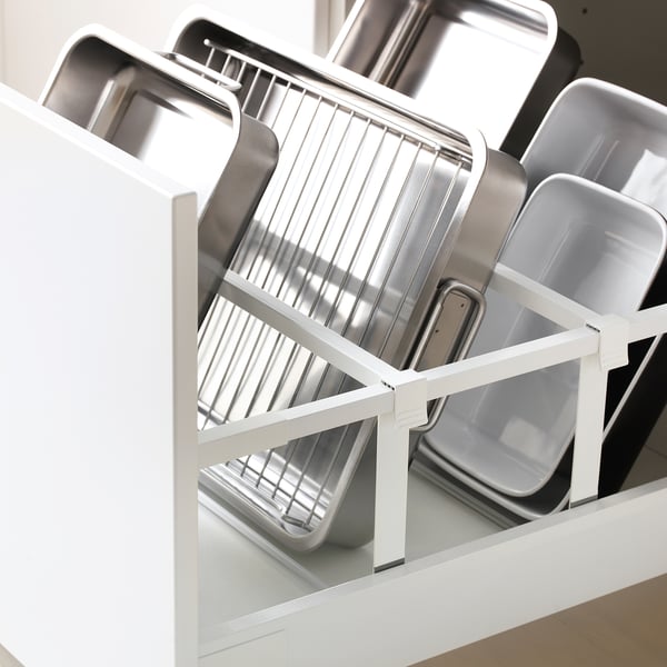 Armoire de cuisine ouverte affichant les plaques de cuisson dans un tiroir METOD blanc pour un rangement organisé.