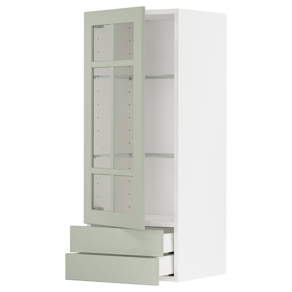 Armoire de cuisine moderne : METOD avec portes en verre vert stensund, cadres blancs, étagère réglable, tiroirs à fermeture douce. Design élégant et vertical.