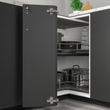 Armoire de cuisine grise, partiellement ouverte avec casseroles, charnières réglables.