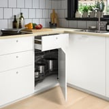 Armoire de cuisine blanche moderne avec étagères d’angle intégrées contenant des casseroles, économisant efficacement de l’espace.