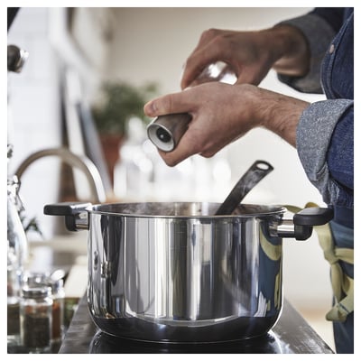 Assaisonner les aliments sur la cuisinière dans la cuisine.