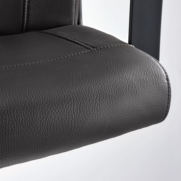 Gros plan sur l’accoudoir d’une chaise de bureau MILLBERGET moderne et noire, présentant une finition lisse de haute qualité et un design robuste.