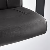 Gros plan sur l’accoudoir d’une chaise de bureau MILLBERGET moderne et noire, présentant une finition lisse de haute qualité et un design robuste.