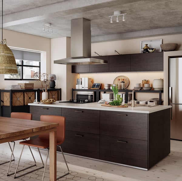 Cuisine moderne avec armoires en bois foncé, grand îlot, appareils électroménagers en acier inoxydable et éclairage sur rail.