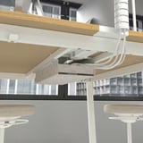 Table de bureau moderne avec gestion intégrée des câbles et repose-pieds pour plus de confort. Idéal pour les réunions.