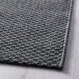 Gros plan de la texture tissée des tapis MORUM, mettant en valeur son matériau gris durable.