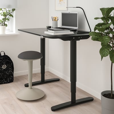 Un tabouret moderne en nylon réglable en hauteur, gris avec une assise et une base rondes, conçu pour une assise active.