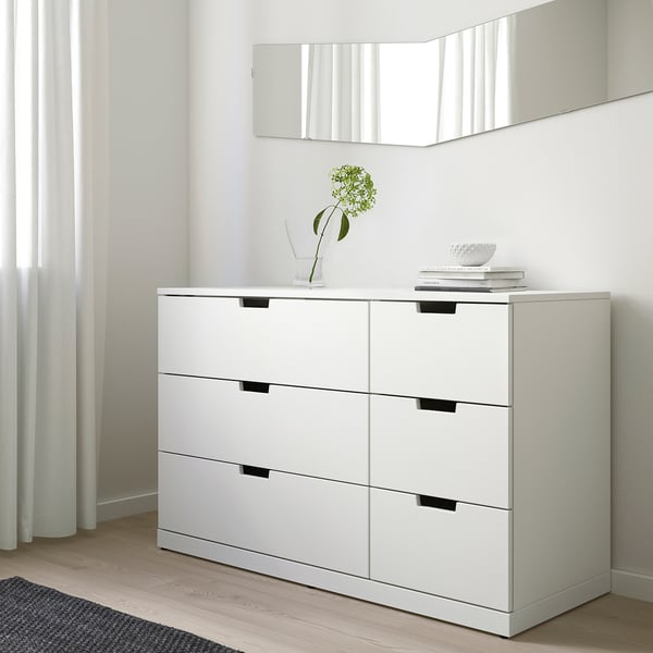 Commode Ikea NORDLI à 6 tiroirs contre le mur, pièce minimaliste, vase à fleurs vertes, livres.