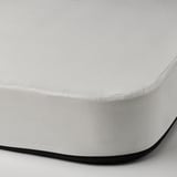 Vue rapprochée d’un matelas blanc de haute qualité avec une bordure épaisse et noire et une fermeture éclair, mettant en valeur sa conception durable et confortable.