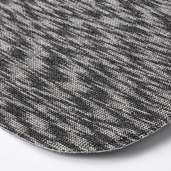 Gros plan d’un coussin de siège rond et texturé avec un motif complexe en noir et blanc. De superbes détails et un savoir-faire évident dans le tissage du tissu.