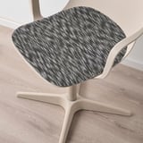Chaise moderne avec coussin d’assise élégant à motifs. Parquet clair, design épuré.