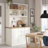 Kitchenette moderne avec armoires, table et œuvres d’art.