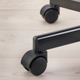 Gros plan d’une roulette de chaises pivotantes, montrant des matériaux de qualité et un design.